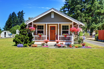 Cute American house exterior with covered porch and flower pots