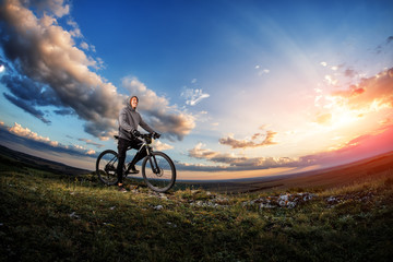 Fototapeta na wymiar Young man cycling on a rural road through meadow