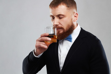 stylish handsome bearded man enjoying a brandy or whiskey.drinking a alcohol