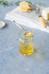 Homemade herbs and sweet white wine jelly in small jar. Selective focus.