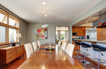 Large wooden dining table with white chairs in cozy house