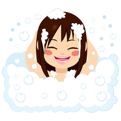 Happy little girl having fun in bubble bath washing hair with foam