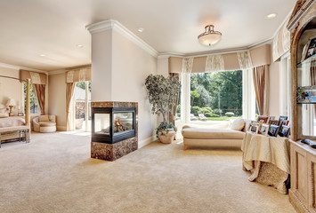 Large master bedroom in luxury home with doors to balcony.