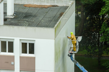 Homme utilisant un nettoyeur haute pression sur une nacelle