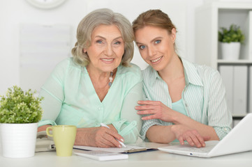  mother and adult daughter with laptop