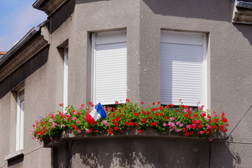 Fototapeta na wymiar Drapeau Français sur le bord d’une fenêtre