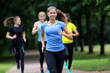 Junge Frau läuft mit Freundinnen im Park