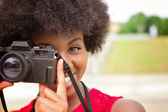 African girl with retro camera taking picture