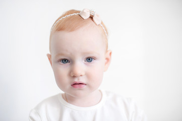 Beautiful red-haired girl with blue eyes and a bow