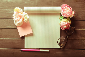 flowers and a notebook on wooden background