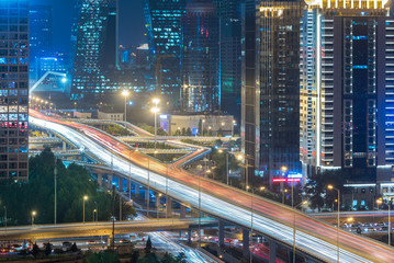 blurred traffic light trails on road at night in China.