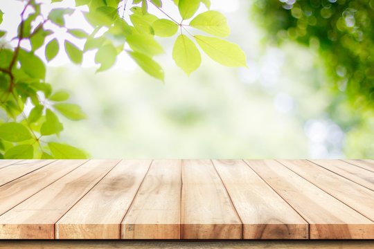 Fototapeta Empty wooden table with garden bokeh background with a country outdoor theme,Template mock up for display of product