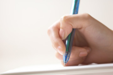 女性の手と筆記用具 