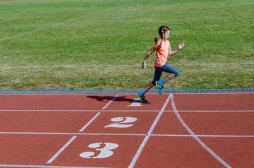 Fototapeta premium Kids sport, child running on stadium track, training and fitness concept 