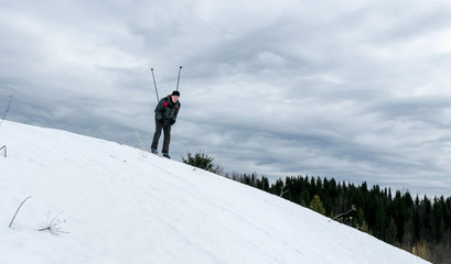 Skier hiker goes downhill in forest virgin snow