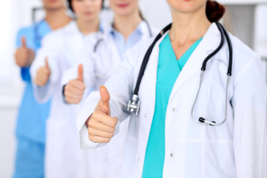 Group of doctors showing OK or approval sign with thumb up. High level and quality medical service, best treatment and patient care concept