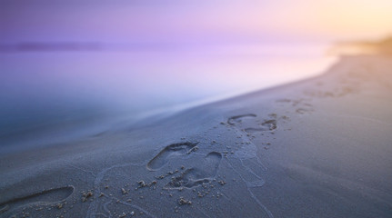 Early morning. Footprints in the sand along the seashore.