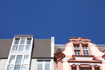 Modern next to historic architecture in Aachen, Germany with townhouses with ornate carving and...