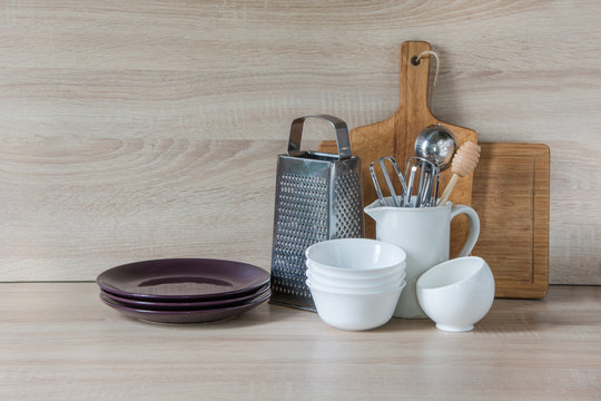 Crockery, tableware, utensils and other different stuff on wooden table-top. Kitchen still life as background for design.  Image with copy space.