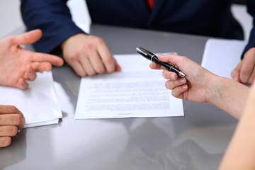 Business lady offering businessman black pen for signing a contract