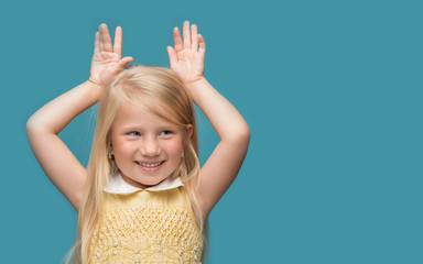 The little girl is thinking about something on a blue background