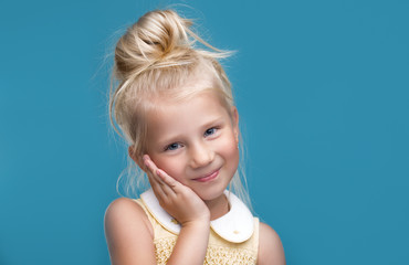 The little girl is thinking about something on a blue background