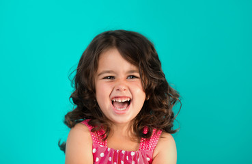 portrait of a happy, positive, smiling, little girl, cyan background