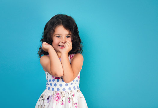 portrait of a happy, positive, smiling, little girl, blue background
