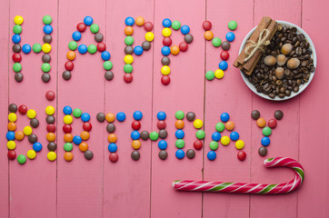 inscription from candies on a pink background