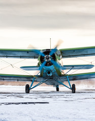 Taxiing single-engine biplane in a cold winter day