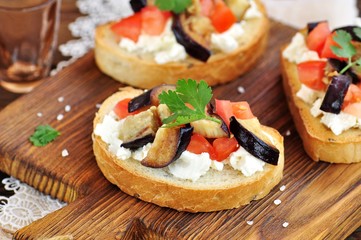 Crostini with soft cheese, eggplant, tomatoes and garlic.