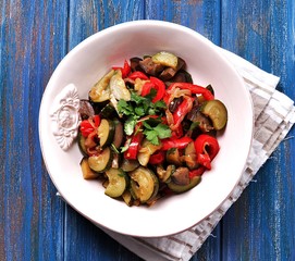 Stewed vegetables in a frying pan zucchini, eggplant, peppers and onions.