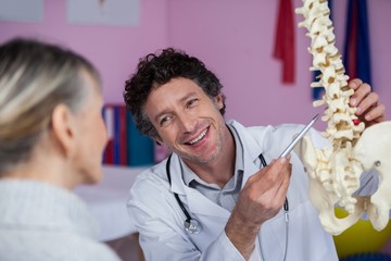 Physiotherapist explaining the spine model to patient