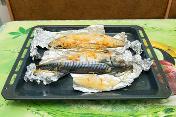 Baked mackerel in foil with vegetable oil and spices. Top view. Recipe home fish with vegetables in...