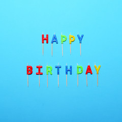 Happy Birthday flat lay party decorations on blue background