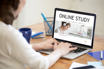 Young happy woman working in office interior, browsing e-learning website. Attractive female...