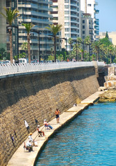 Men fish on big city quay