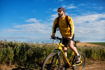 Naklejka premium Young man cycling on a rural road
