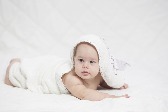 Adorable girl baby, wrapped in bath towel after bathing .