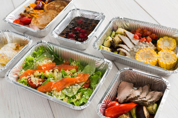 Healthy food take away in boxes, top view at wood