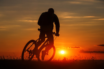 Fototapeta na wymiar Silhouette of a bike on sky background during sunset