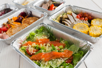 Healthy food take away in boxes, top view at wood