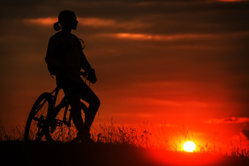Fototapeta na wymiar Silhouette of a bike on sky background during sunset