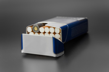 a pack of cigarettes with one live ammunition in a pack