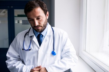 Sad doctor standing in corridor