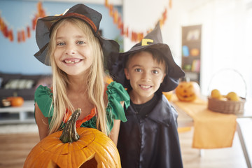 Brother and sister holding big pumpkin..