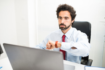 Impatient businessman snorting while watching his watch