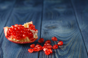 Pomegranate slices and garnet fruit seeds on table. Selective fo