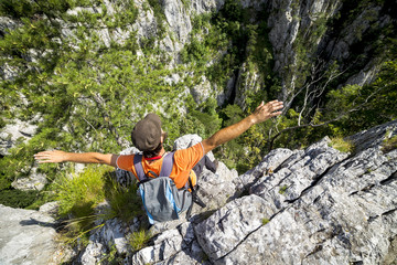 Hiker young man stretching his arms on the mountain