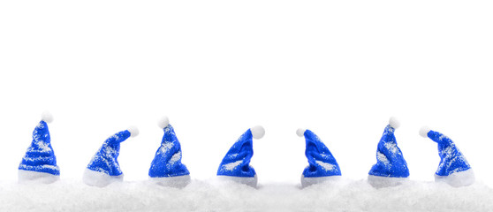 Blaue Weihnachtsmützen im Schnee (freigestellt)